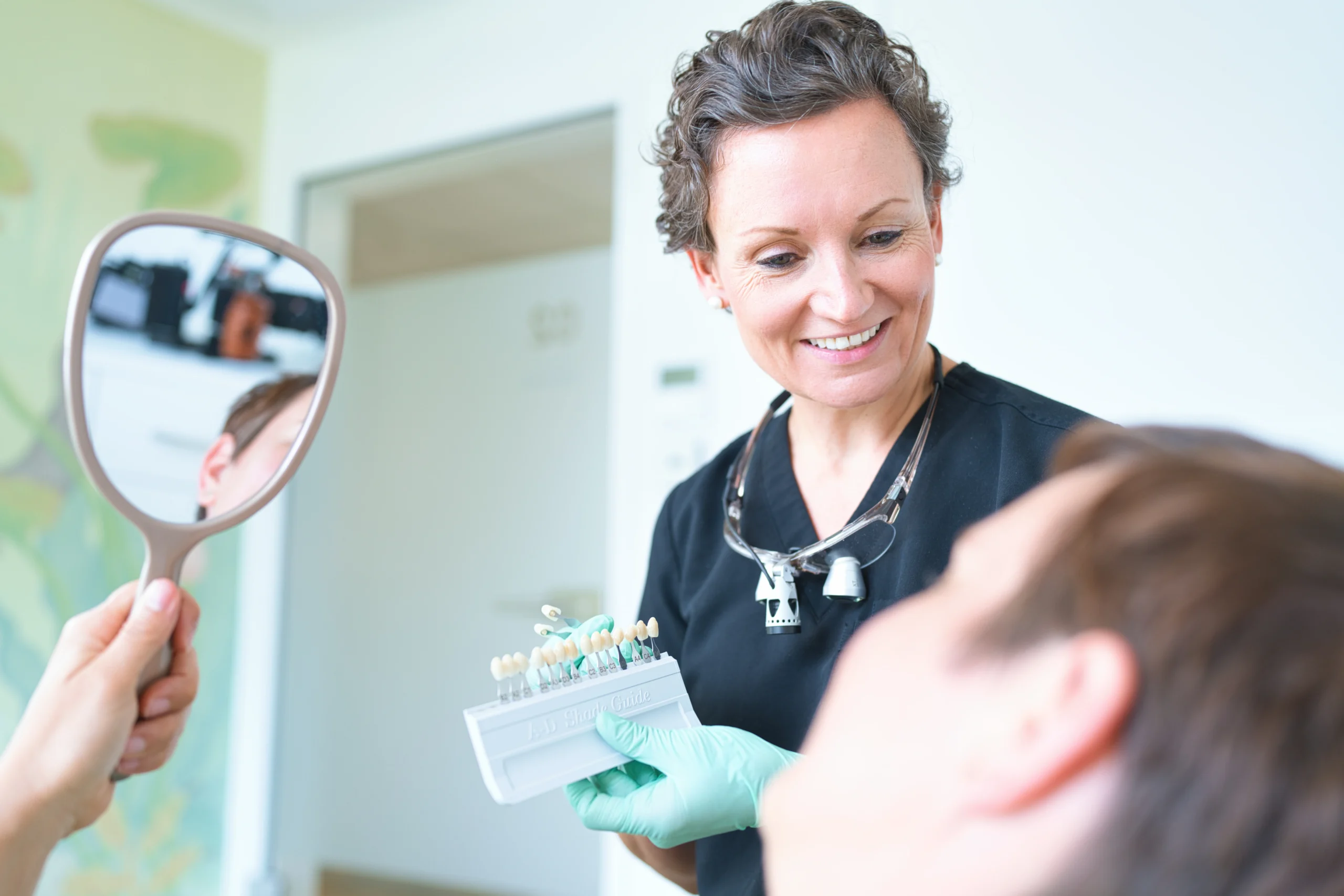 Dr. Lea von Einsiedel begleitet eine Patientin beim Blick in den Handspiegel.