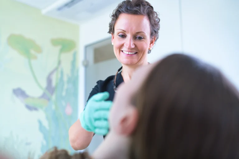 Dr. Lea von Einsiedel spricht mit einer Patientin im Behandlungsstuhl.