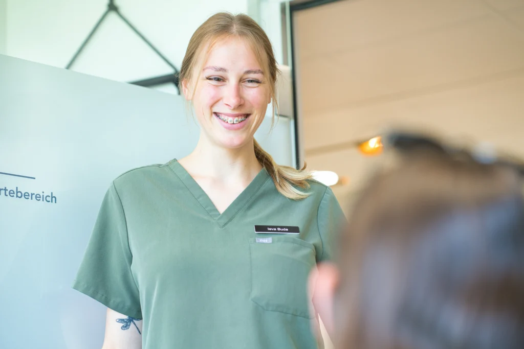 Eine Mitarbeiterin spricht mit einer Patientin im Behandlungszimmer.