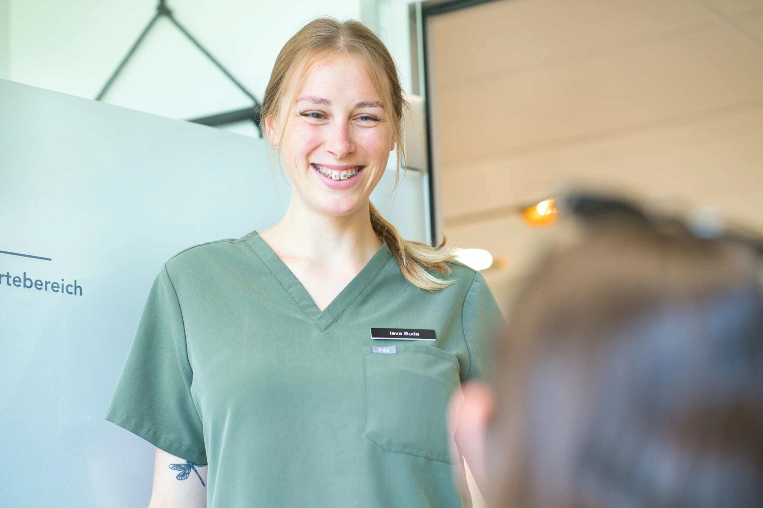 Eine Mitarbeiterin spricht mit einer Patientin im Behandlungszimmer.