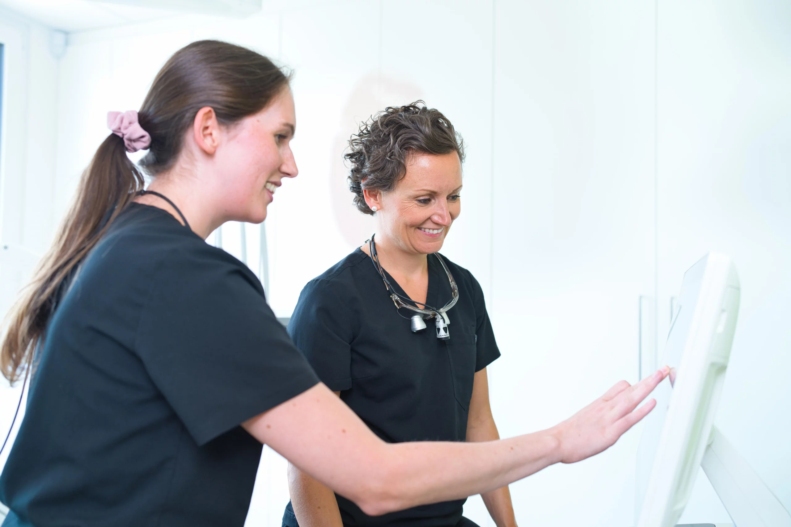 Dr. Lea von Einsiedel und eine Mitarbeiterin arbeiten gemeinsam am Touchscreen.
